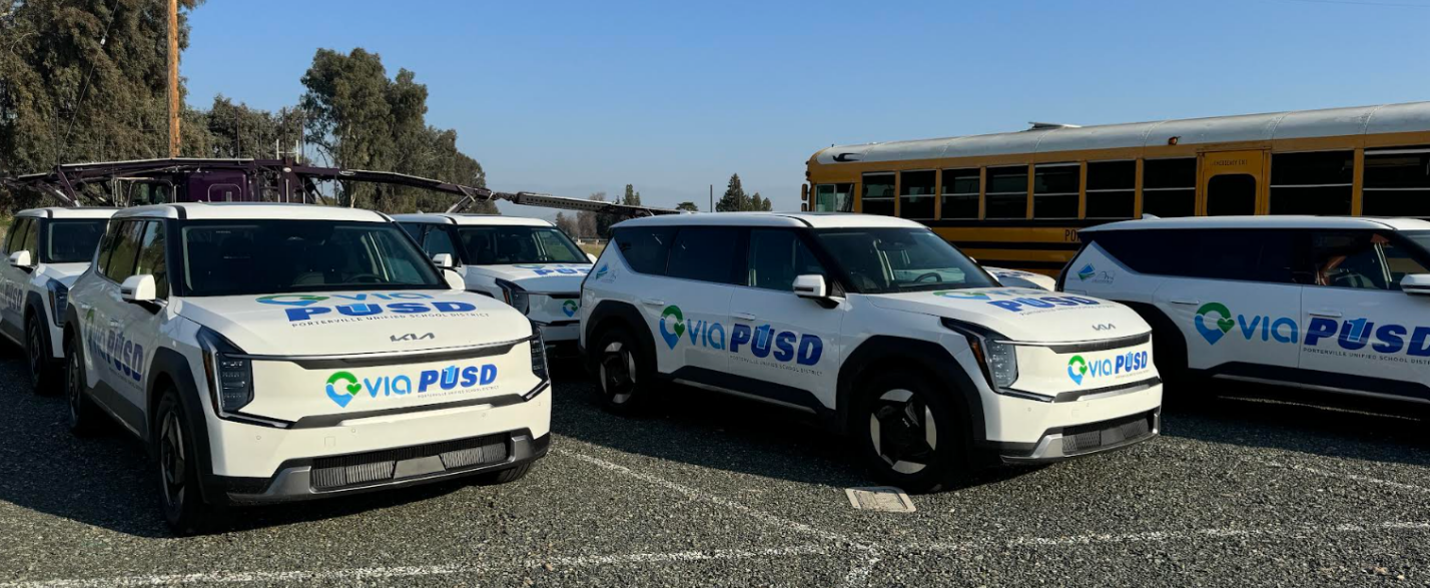 Zero emission microtransit fleet lined up with VIA and CCI logos on the side