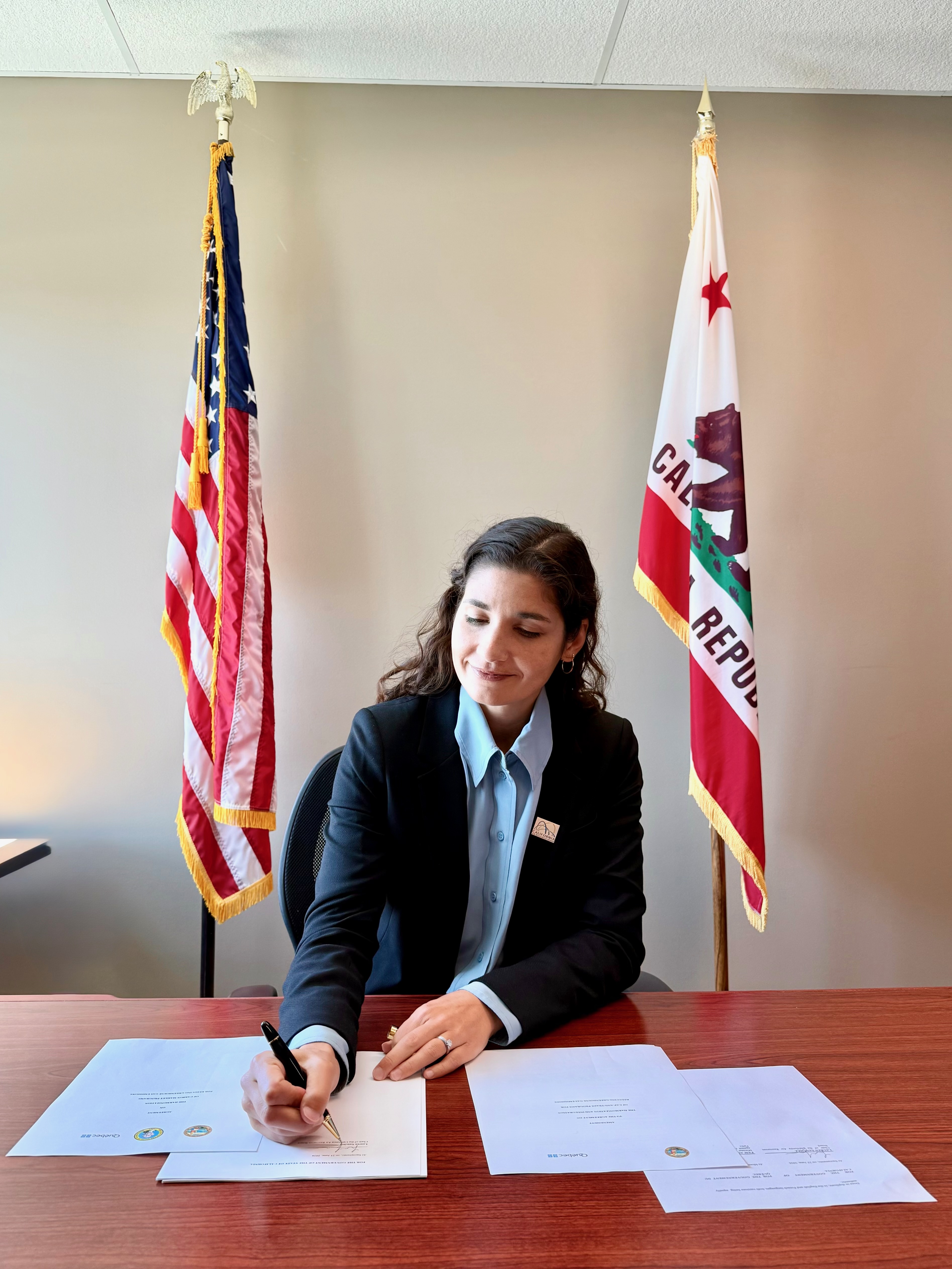 CARB Chair Lauren Sanchez signs linkage agreement from her office in Sacramento.
